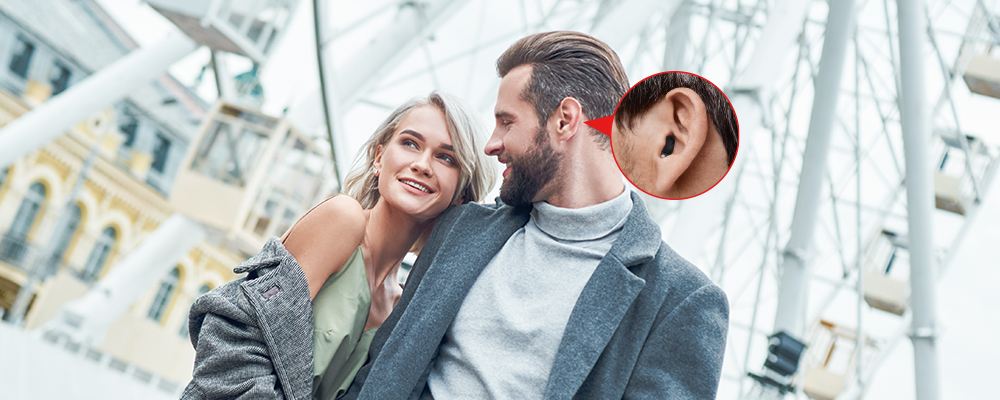 Ein Paar, wobei der Mann ein Hörgerät trägt.